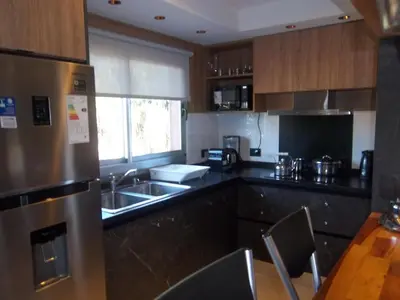 a kitchen with a stainless steel refrigerator and a sink at Departamento Brisas del Lago in Villa Carlos Paz