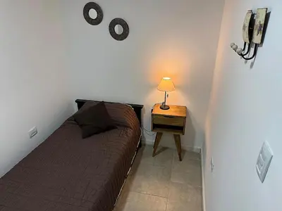a small bedroom with a bed and a table with a lamp at Nueva Córdoba Ejecutivo in Cordoba