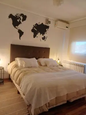 a bedroom with a large bed with continents on the wall at Village Tower - Hermoso departamento en excelente ubicación in Villa Carlos Paz