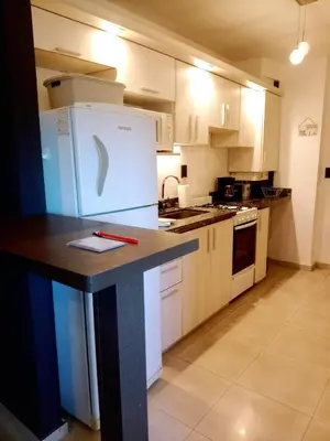 a kitchen with white cabinets and a white refrigerator at Village Tower - Hermoso departamento en excelente ubicación in Villa Carlos Paz