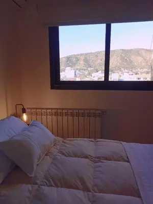 a bedroom with a large bed with a window at Village Tower - Hermoso departamento en excelente ubicación in Villa Carlos Paz