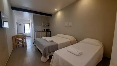 a hotel room with two beds and a table at Olmos Suites in Mina Clavero
