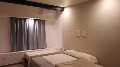 a room with two beds and a window at Olmos Suites in Mina Clavero