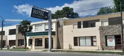 a sign for a hotel in front of a building at Los Robles in Villa Cura Brochero