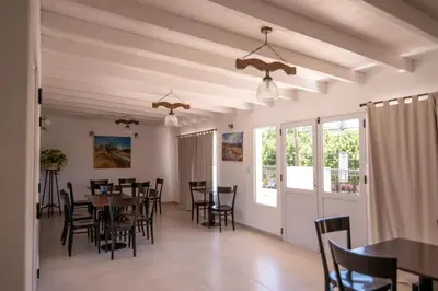 a dining room with tables and chairs and windows at Los Robles in Villa Cura Brochero