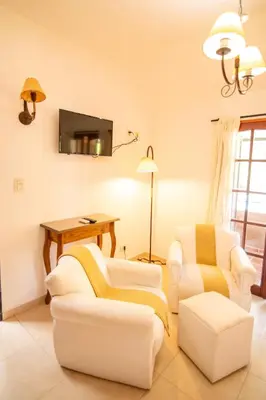 a living room with two chairs and a table at Los Robles in Villa Cura Brochero