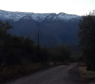 a dirt road with snow capped mountains in the distance at Cabañas La Ramadita in La Ramada