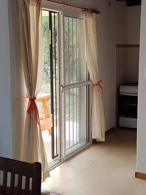 an open sliding glass door with curtains in a kitchen at Cabañas La Ramadita in La Ramada