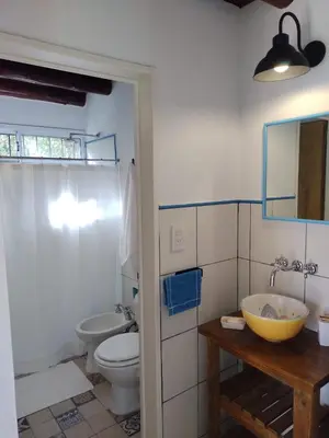 a bathroom with a sink and a toilet and a mirror at Cabañas La Ramadita in La Ramada