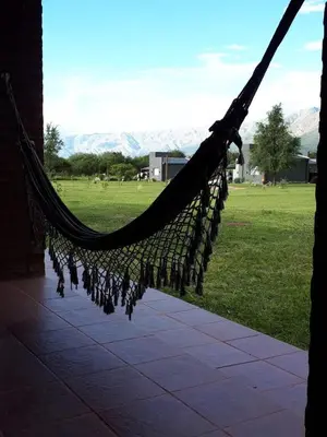 a hammock with a view of a field and mountains at Cabañas Mini Tinkuy in Cortaderas