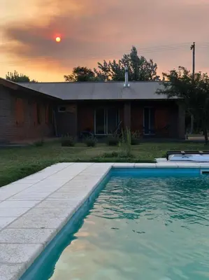 a house with a swimming pool in front of a house at Cabañas Mini Tinkuy in Cortaderas