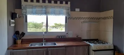a kitchen with a sink and a stove and a window at Cabañas Mini Tinkuy in Cortaderas