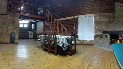 a dining room with a table in a stone building at Cabañas Postal de la Villa in Villa Carlos Paz