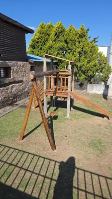 a shadow of a person standing next to a playground at Cabañas Postal de la Villa in Villa Carlos Paz