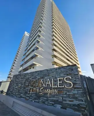 a building with a sign on it with two tall buildings at Departamento 1 dormitorio con pileta gimnasio y sala de juegos in Cordoba