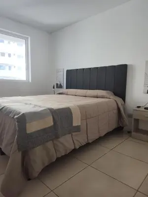 a bedroom with a large bed with a blanket at Departamento 1 dormitorio con pileta gimnasio y sala de juegos in Cordoba