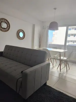 a living room with a couch and a table at Departamento 1 dormitorio con pileta gimnasio y sala de juegos in Cordoba