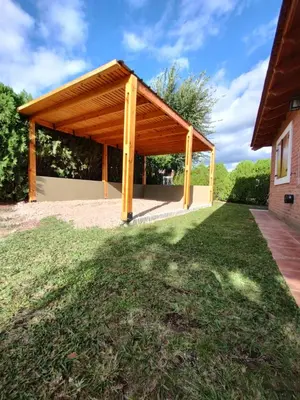 a pavilion with a wooden roof on a lawn at Tres Deseos in Villa Cura Brochero