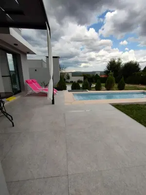 a patio with a pool and an umbrella at Tres Deseos in Villa Cura Brochero