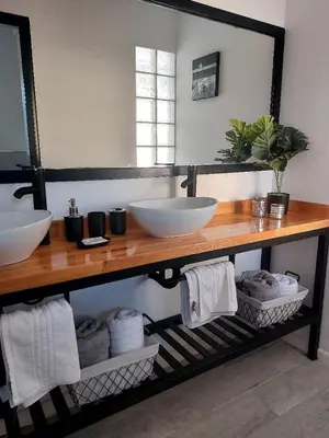 a bathroom with two sinks on a wooden counter at Tres Deseos in Villa Cura Brochero