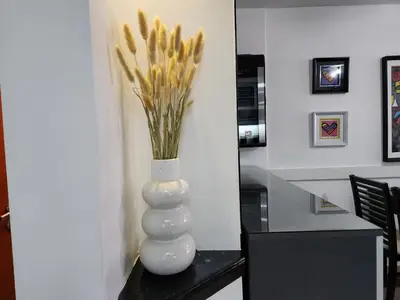 a white vase with flowers in it on a table at Beautiful and modern apartment in Alta Gracia in Alta Gracia