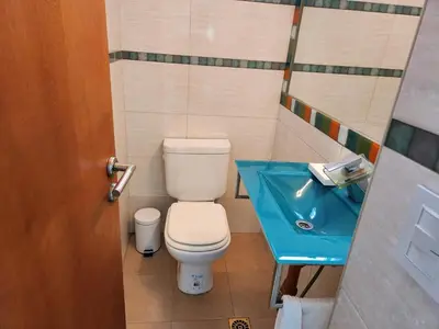 a bathroom with a toilet and a blue sink at Beautiful and modern apartment in Alta Gracia in Alta Gracia
