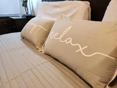 a bed with two pillows with the word relax on it at Beautiful and modern apartment in Alta Gracia in Alta Gracia