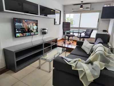 a living room with a couch and a tv on the wall at Beautiful and modern apartment in Alta Gracia in Alta Gracia