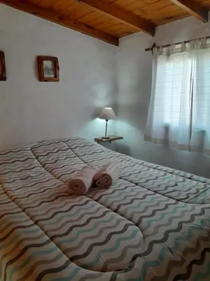 a bedroom with a large bed with a blanket at Cabañas de Panaholma in Panaholma