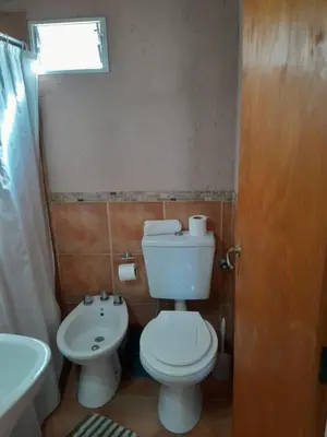 a bathroom with a white toilet and a sink at Cabañas de Panaholma in Panaholma