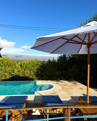 a white umbrella and chairs and a swimming pool at Cabañas de Panaholma in Panaholma