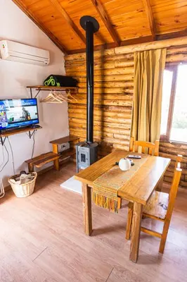 a living room with a wooden table and a stove at Cabañas de Panaholma in Panaholma