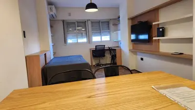a room with a table and chairs and a desk at Av General Paz 418 Centro Parking economico in Cordoba