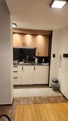 a kitchen with white cabinets and black appliances at Av General Paz 418 Centro Parking economico in Cordoba