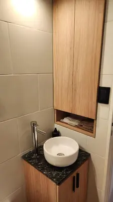 a bathroom with a sink and a wooden cabinet at Av General Paz 418 Centro Parking economico in Cordoba