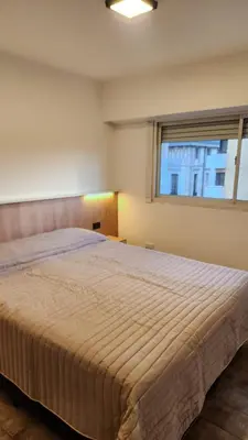 a large bed in a bedroom with a window at Av General Paz 418 Centro Parking economico in Cordoba