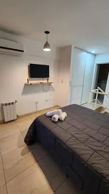 a large bed in a room with a flat screen tv at Deheza II- Gral Paz-BY Apartments in Cordoba