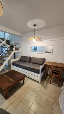 a bedroom with a bed and a table and stairs at Deheza II- Gral Paz-BY Apartments in Cordoba