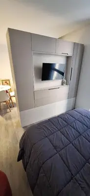 a bedroom with a bed and a wall with a tv at Miralejos 17 in Villa Carlos Paz
