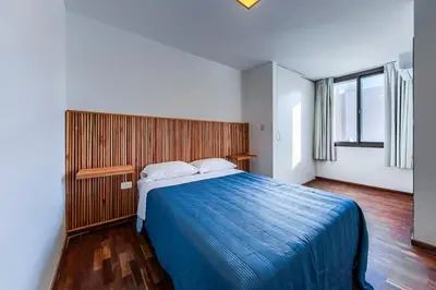 a bedroom with a large bed with a blue blanket at Lavalleja II in Cordoba