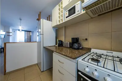 a small kitchen with a stove and a microwave at Lavalleja II in Cordoba