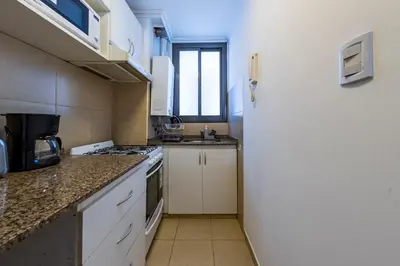 a kitchen with a stove and a white refrigerator at Lavalleja II in Cordoba