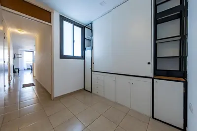 an empty room with white cabinets and a window at Lavalleja II in Cordoba