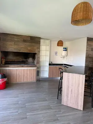 a kitchen with a counter and chairs in a room at ALOJATE PREMIUM VILLA CARL0S PAZ -Liniers in Villa Carlos Paz