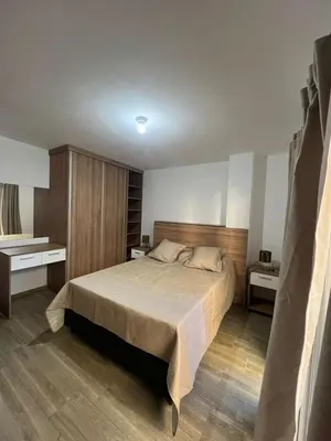 a bedroom with a large bed and two night stands at ALOJATE PREMIUM VILLA CARL0S PAZ -Liniers in Villa Carlos Paz