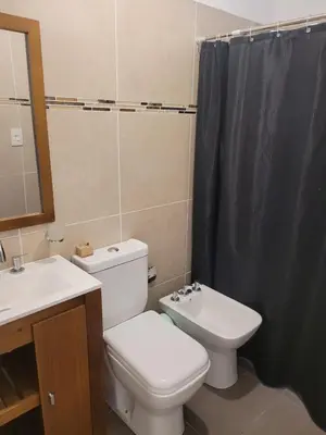 a bathroom with a toilet and a sink and a mirror at Tu Nuevo Hogar in Alta Gracia