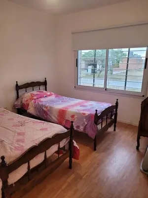 two beds in a room with a window at Tu Nuevo Hogar in Alta Gracia