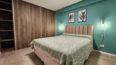 a bedroom with a bed and a blue wall at Torre GNI Cofico in Cordoba