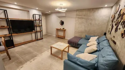 a living room with a blue couch and a flat screen tv at Torre GNI Cofico in Cordoba