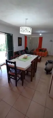 a dining room with a table and chairs and a living room at Pan de Azúcar 3 dias mínimo de alojamiento in Villa Parque Siquiman